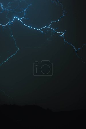 Big blue lightning striking the dark sky.