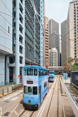 Téléchargez les photos : Hong Kong, Chine - 10 avril 2023 : Célèbre tramway bleu à deux étages dans la rue de l "île de Hong Kong, devant le bâtiment HSBC - en image libre de droit