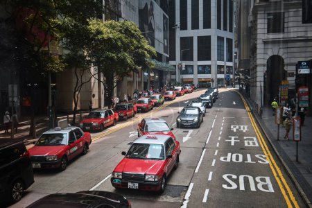 Téléchargez les photos : Hong Kong, Chine - 10 avril 2023 : Rangée de taxis rouges dans une rue du centre-ville de Central - en image libre de droit