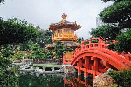 Téléchargez les photos : Hong Kong - Avril 2023 : Pont en bois orange et pavillon doré d'une perfection absolue dans "Nan Lian Garden" dans "Chi Lin Nunnery" - en image libre de droit