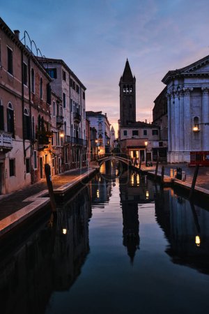 Photo for Venice, Italy - November 9 2023: Bell tower of Chiesa di San Barnaba and narrow canal in Venice at dawn - Royalty Free Image