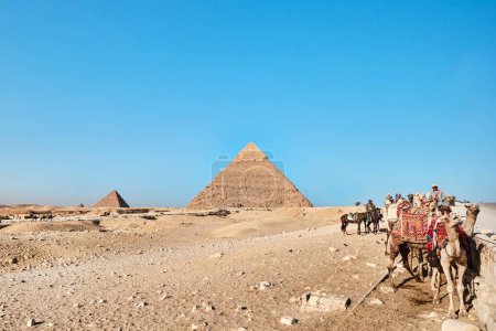 Foto de Giza, Egipto - 24 de diciembre de 2023: Pirámide de Khafre (también conocida como Khafra, Khefren) y Menkaure con camellos - Imagen libre de derechos