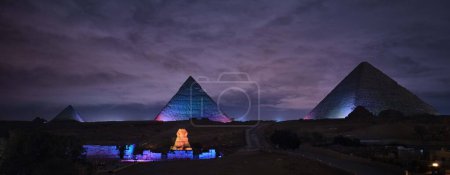 Foto de Giza, Egipto - 24 de diciembre de 2023: Las pirámides y la esfinge en las luces de la noche - Imagen libre de derechos