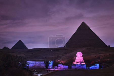 Foto de Giza, Egipto - 24 de diciembre de 2023: Las pirámides y la esfinge en las luces de la noche - Imagen libre de derechos