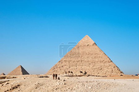 Foto de Giza, Egipto - 24 de diciembre de 2023: Pirámide de Khafre (también conocida como Khafra, Khefren) y Menkaure con camellos - Imagen libre de derechos