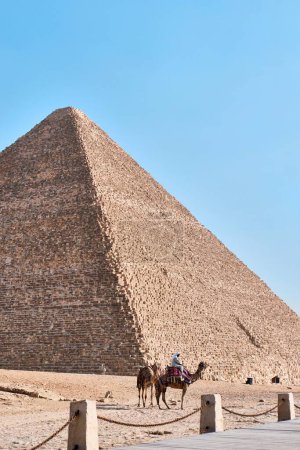 Foto de Giza, Egipto - 24 de diciembre de 2023: La Gran Pirámide de Khufu (Pirámide de Keops) es la más antigua y grande de las tres pirámides y camellos de Giza - Imagen libre de derechos
