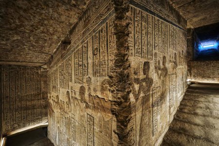 Foto de Dendera, Egipto - 28 de diciembre de 2023: Corredores con antiguos jeroglíficos y relieves en el templo de la diosa Hathor en el Complejo del Templo de Dendera - Imagen libre de derechos