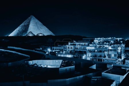 Foto de Giza, Egipto - 24 de diciembre de 2023: La Gran Pirámide de Khufu (Pirámide de Keops) es la más antigua y más grande de las tres pirámides de Giza por la noche. - Imagen libre de derechos