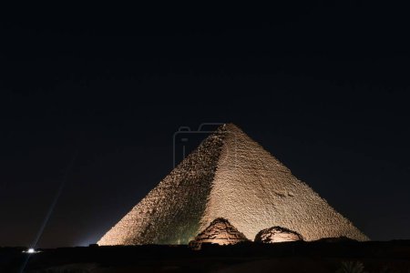 Foto de Giza, Egipto - 24 de diciembre de 2023: La Gran Pirámide de Khufu (Pirámide de Keops) es la más antigua y más grande de las tres pirámides de Giza por la noche. - Imagen libre de derechos
