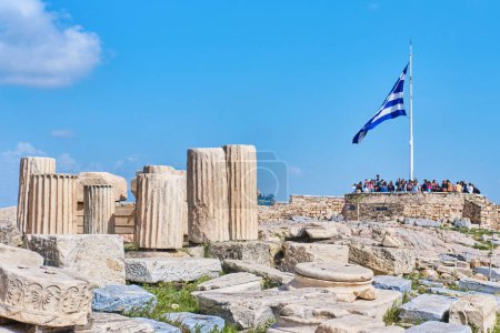 Photo for Athens, Greece - March 02, 2024: Huge Greek flag waving on the top of Acropolis site next to the Parthenon overlooking the city - Royalty Free Image