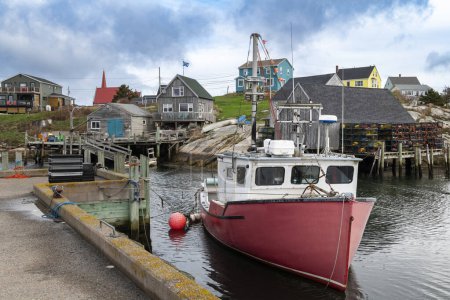 View of a fishing boat in the harbor with the houses on the background, in the fishing village of Peggy's Cove, in Southern Nova Scotia, Canada.