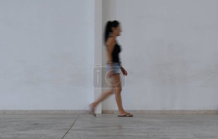 Téléchargez les photos : Femme marchant devant un mur - en image libre de droit