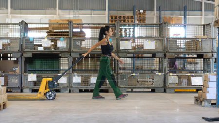 Téléchargez les photos : Travailleur marchant dans un entrepôt avec un chariot élévateur - en image libre de droit