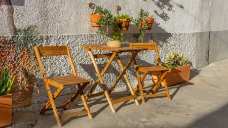 Téléchargez les photos : Jardin ensoleillé : Chaise vide dans une oasis de plein air en fleurs - en image libre de droit