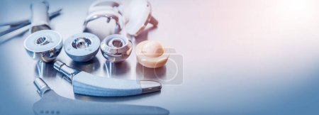 Photo for Close up of lots of parts for transplantation of leg joints and tools for surgical operations on replacement of joints lie against a metal surface - Royalty Free Image