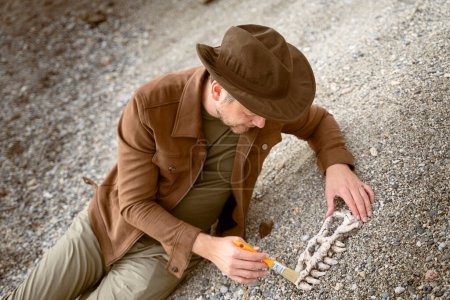 Foto de Paleontólogo arqueólogo descubre huesos de cráneo de dinosaurio - Imagen libre de derechos