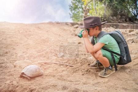 Foto de Pequeño turista naturalista estudiando una tortuga en la naturaleza - Imagen libre de derechos