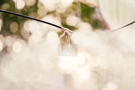 Photo for Close up outdoors shot of some mist or fog wire working at a cafe terrace in summer. - Royalty Free Image