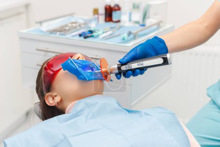 Konzentrierte Zahnärztin arbeitet und macht Behandlungen an einer Patientin.
