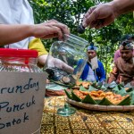 Bogor City, Indonesia - July 23, 2023 - Buyers pay for snacks of fried cassava with coconut shell chips worth one shell as a means of payment in lieu of money at a village snack festival