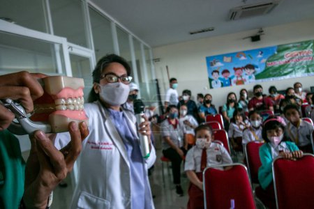 Photo for Bogor, Indonesia - July 31, 2023: Dentists provide education on how to maintain dental hygiene and health to elementary school students who visit the Vania Bogor Hospital, in Indonesia - Royalty Free Image