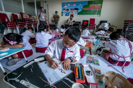 Photo for Bogor, Indonesia - July 31, 2023: Elementary school students in Bogor City, Indonesia, carry out coloring activities on health-themed pictures while visiting the Vania Bogor Hospital - Royalty Free Image