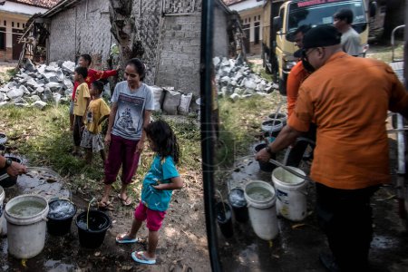 Photo for Bogor, Indonesia - August 07, 2023: Residents in Bogor, West Java, who are affected by drought and lack of clean water due to the dry season receive clean water assistance from the government - Royalty Free Image