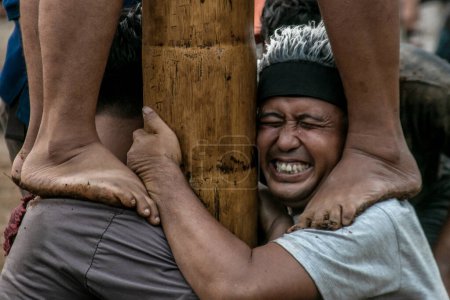 Photo for Bogor, Indonesia - August 20, 2023: Residents race to climb a betel nut whose trunk has been treated with a lubricating liquid to compete for prizes of items hung on it in Bogor, West Java, in celebration of Indonesia's 78th Independence Day - Royalty Free Image