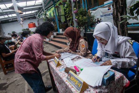 Foto de Funcionarios electorales con uniformes de escuela secundaria en un centro de votación, durante las elecciones generales de 2024 en Bogor, Indonesia, el 14 de febrero de 2024. - Imagen libre de derechos
