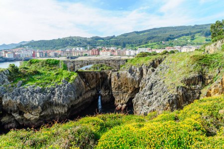Téléchargez les photos : Un sentier pédestre pittoresque le long de la côte rocheuse avec vue sur la ville de Castro Urdiales et des collines luxuriantes en arrière-plan. - en image libre de droit