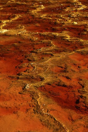 Close-up of iron sulfate formations creating a mosaic of reds and oranges in the Rio Tinto's waters