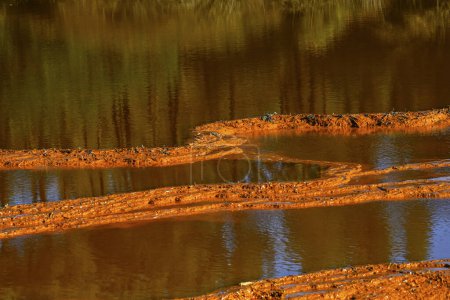 Sunset illuminates the terraced mineral pools, showcasing the vibrant geological layers at Rio Tinto