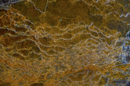 Micro-channels snake through the iron and sulfur-laden rocks of Rio Tinto, creating an abstract natural pattern