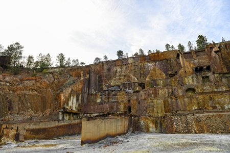 Decaying remains of mining structures stand over a stagnant water body at the Rio Tinto mines, a relic of industrial activity