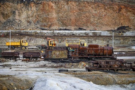 Weathered mining equipment, including trucks and rail cars, sits in the historic Rio Tinto mines, a testament to past industry