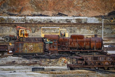 Weathered mining equipment, including trucks and rail cars, sits in the historic Rio Tinto mines, a testament to past industry