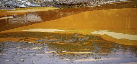 The acidic waters of Rio Tinto reflect a vivid orange hue from the iron and sulfur sedimentation along the riverbank