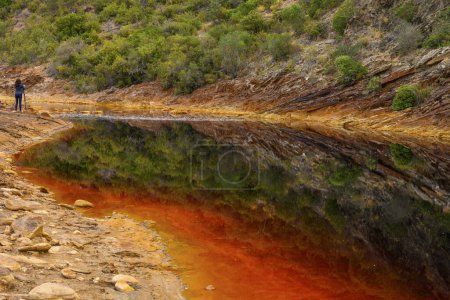Photo for Striking layers of earth and a vivid streak of red water line the cracked ground of the Rio Tinto - Royalty Free Image