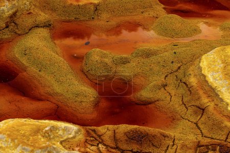 Striking yellow mineral concretions stand out against the intense red of Rio Tintos acidic waters