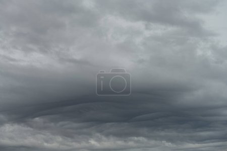 Expansive asperitas clouds form a dramatic wave-like pattern across the overcast sky, signaling changing weather patterns