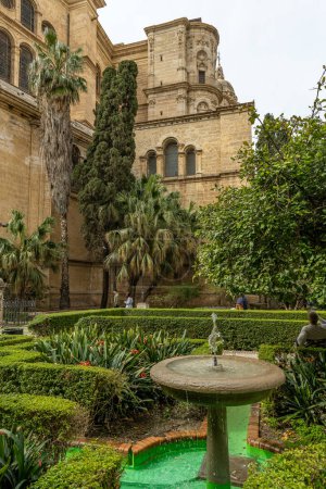 El icónico campanario de la Catedral de Málaga se eleva majestuosamente entre los edificios tradicionales españoles en el corazón de la ciudad.