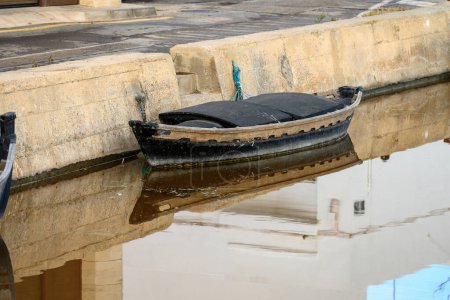A partially submerged and forgotten boat at a weathered dock reflects a story of neglect in the waters of Albufera Valencia