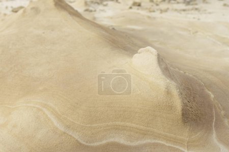 Close-up of a smooth sandstone surface featuring gentle erosion patterns and subtle textures. Ideal for backgrounds, nature themes, and geological studies.
