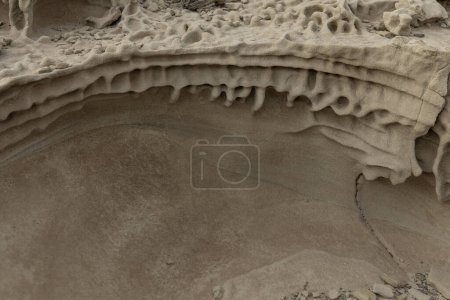 Close-up of sandstone rocks showcasing detailed honeycomb weathering patterns and natural textures. Ideal for geological studies and nature themes.