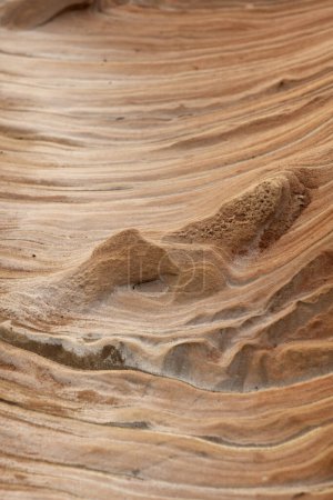 Close-up of intricate sandstone swirls and erosion patterns, highlighting the natural beauty and texture of sedimentary rock formations. Perfect for geological themes and backgrounds.