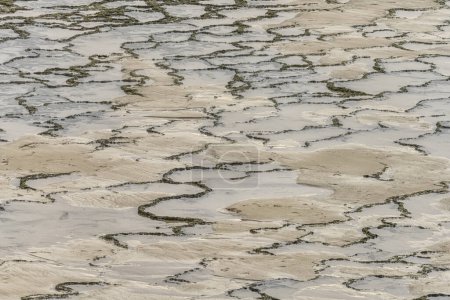 Modèles de marée complexes et textures de sable créés par le reflux de l'eau à Vila Nova de Milfontes, Portugal. Un design unique et naturel par les forces côtières.