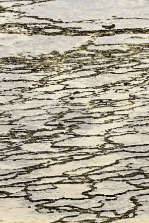 Modèles de marée complexes et textures de sable créés par le reflux de l'eau à Vila Nova de Milfontes, Portugal. Un design unique et naturel par les forces côtières.