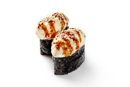 Téléchargez les photos : Deux appétissants sushi gunkan maki de riz enveloppé dans du nori avec garniture d'anguille habillée de sauce unagi épicée et de sésame sur fond blanc. Cuisine traditionnelle japonaise - en image libre de droit