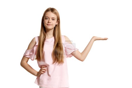 Téléchargez les photos : Studio portrait of a lovely blonde teenage girl in a pink t-shirt isolated on white background in various poses. She expresses different emotions posing right in front of the camera, smiling and - en image libre de droit