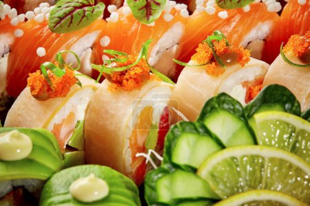 Lebendige Nahaufnahme verschiedener Sushi-Rollen mit Lachs, Avocado und Mamenori, garniert mit Tobiko, Gurken- und Limettenscheiben. Beliebter Snack im asiatischen Stil